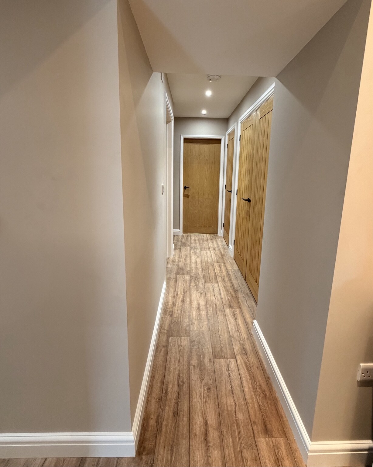Finished hallway with new flooring and oak doors