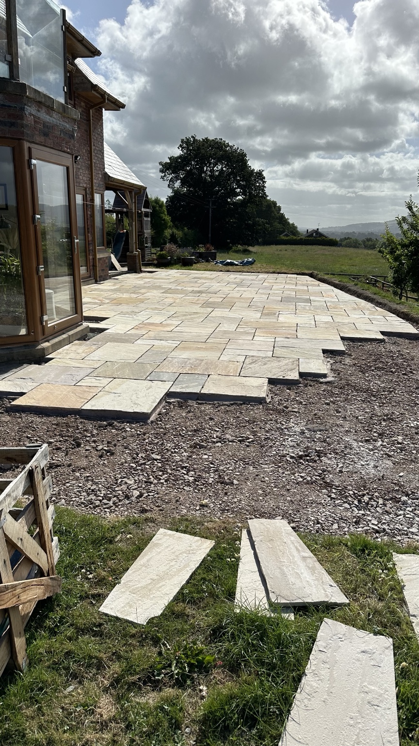Large Indian sandstone patio during the laying stage